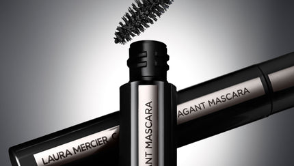 Two Laura Mercier Caviar Extravagant  Mascara tubes on a gray background.