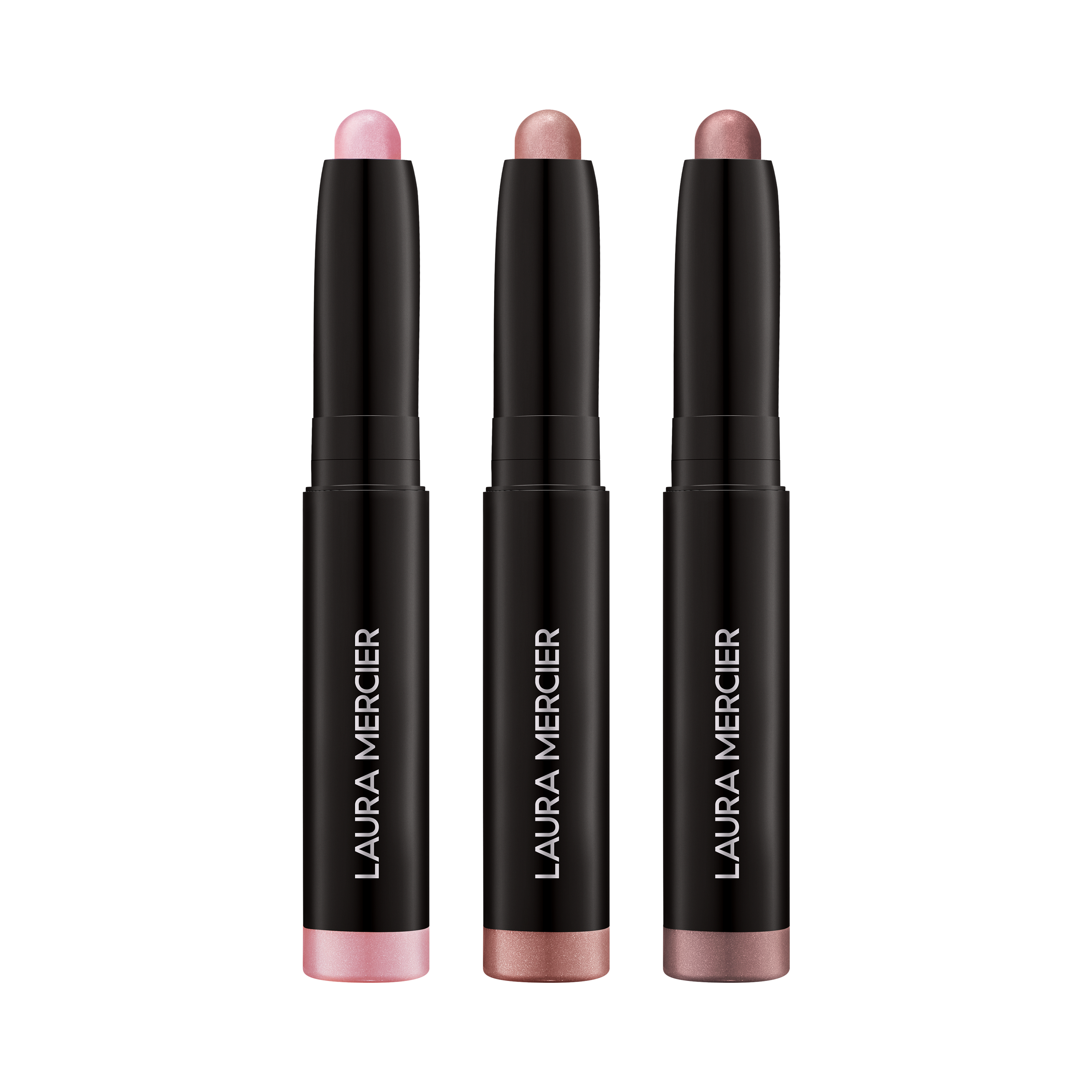 Three Laura Mercier eye shadow sticks on a transparent background
