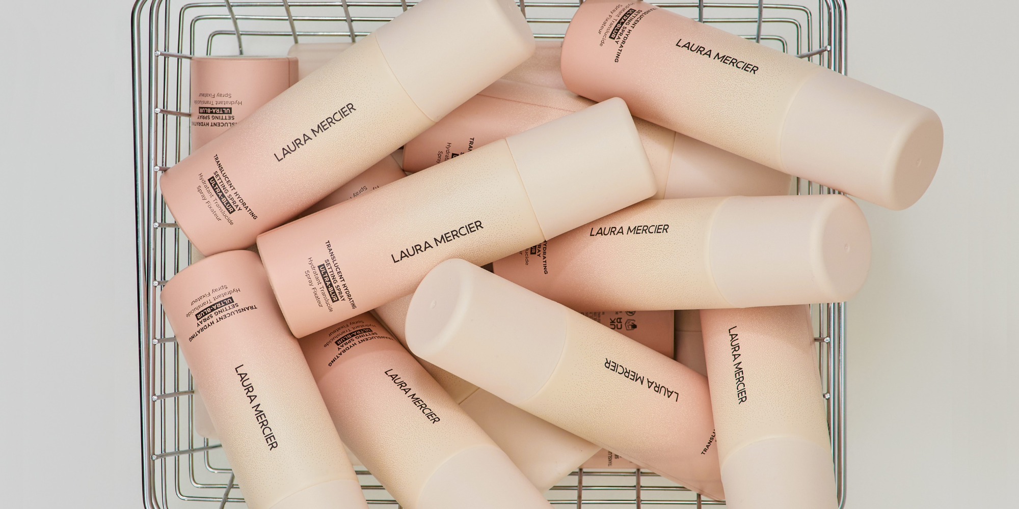 Laura Mercier Translucent Hydrating Setting Spray Ultra-Blur piled into a basket