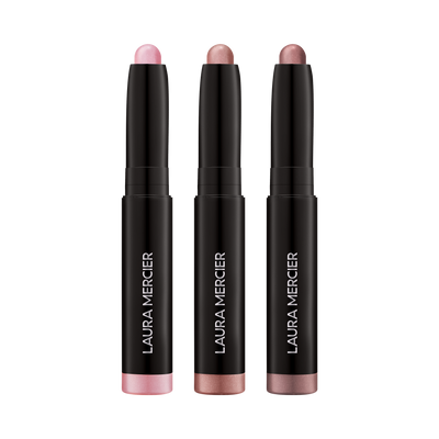 Three Laura Mercier eye shadow sticks  on a transparent background